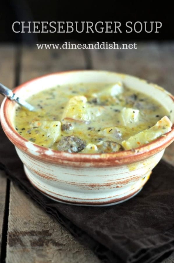 Tan bowl of cheeseburger soup on a brown napkin with a rustic wood background.