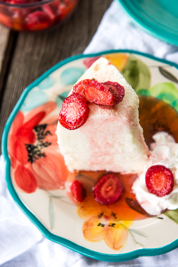Image shows a slice of angel food cake topped with strawberries