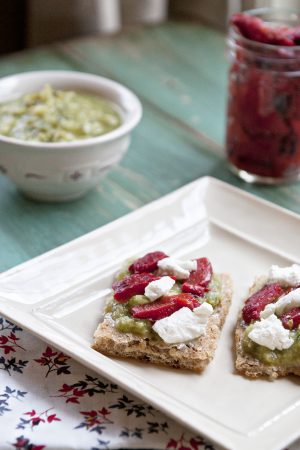 Avocado Verde with red roasted peppers and goat cheese on a whole grain pizza crust
