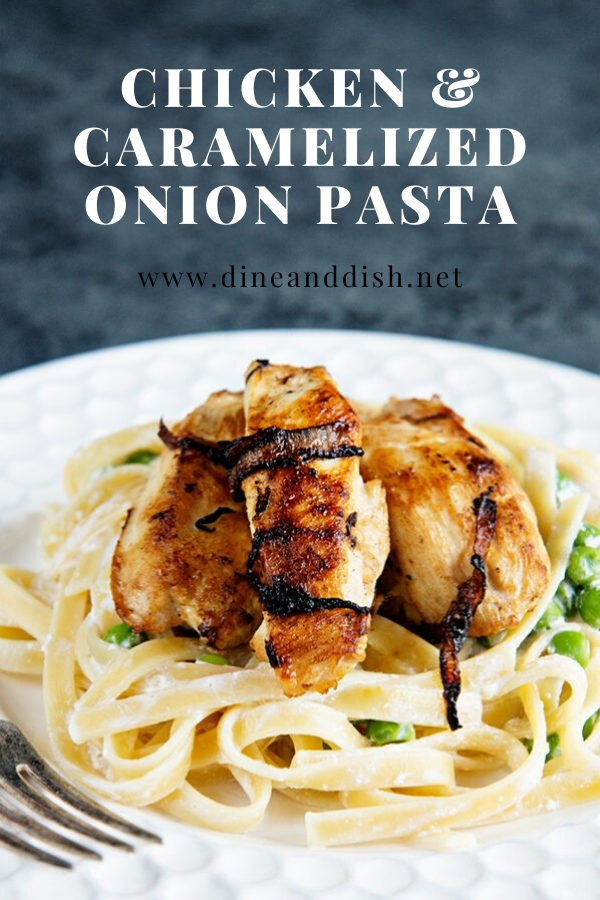 white plate with chicken, pasta and caramelized onions on grey backdrop