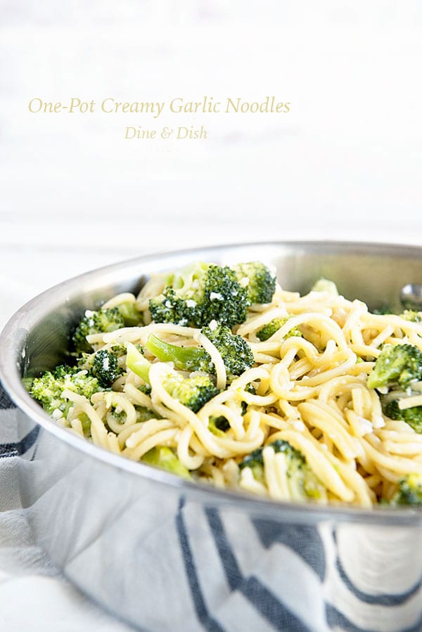 One silver saucepan of spaghetti with broccoli on a white background