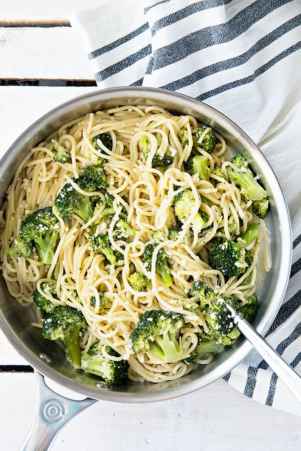A horizontal image of spaghetti with broccoli in a silver pan.