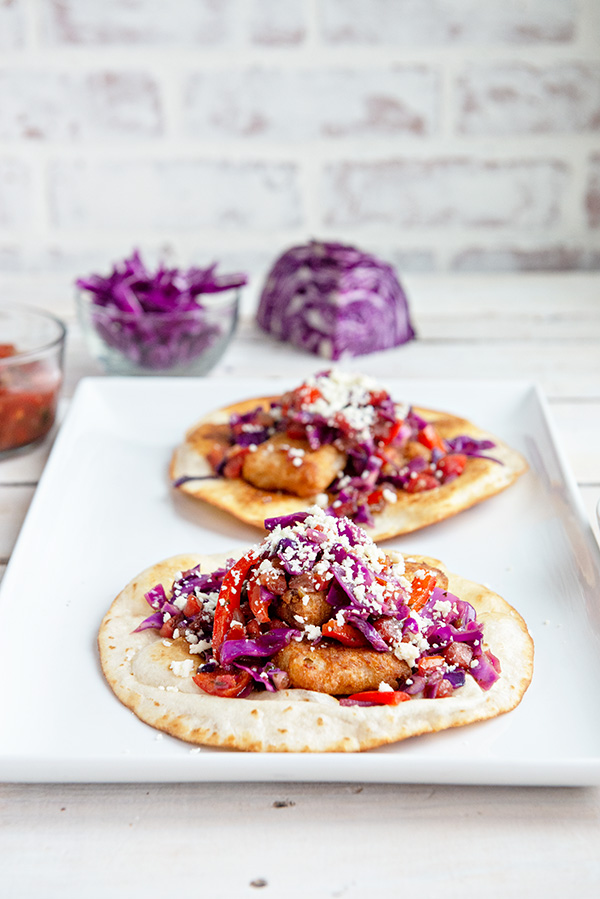 2 Fish Tostadas on a white platter with purple cabbage