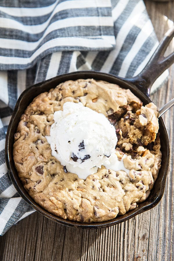 Gooey Jumbo Chocolate Chip Cookie in a Cast Iron Skillet topped with ice cream