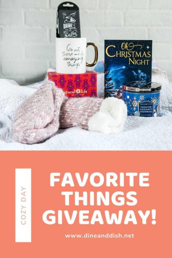 A group of cozy day necessities including socks, coffee mug, book, candle and bookmark