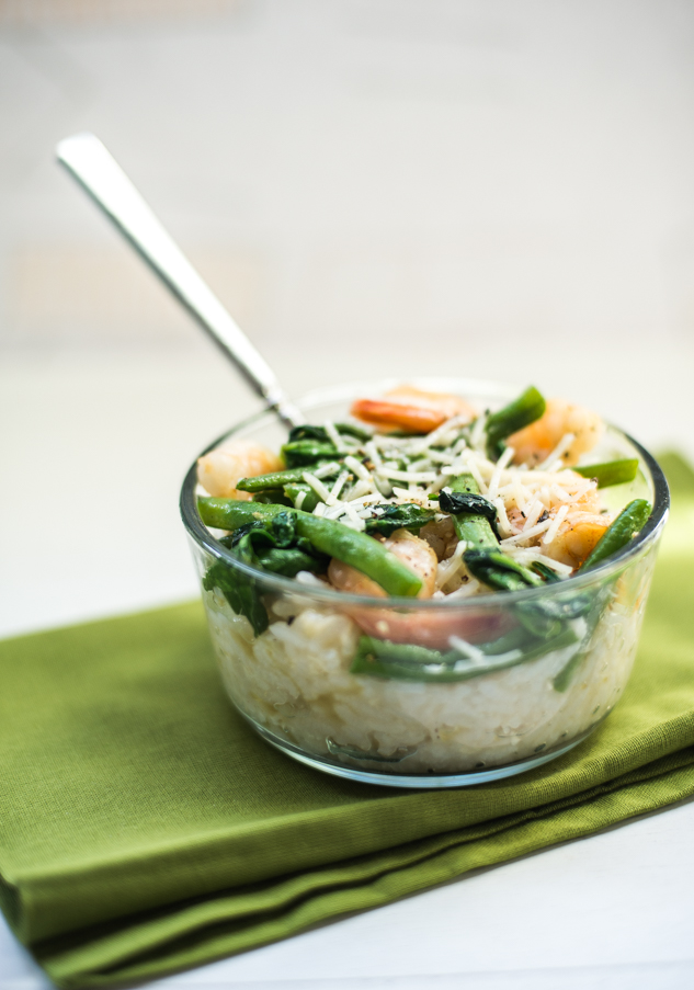 Glass bowl with spinach, shrimp, green beans and risotto