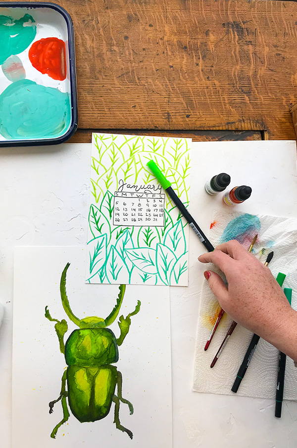 desk with a watercolor painting of a green bug