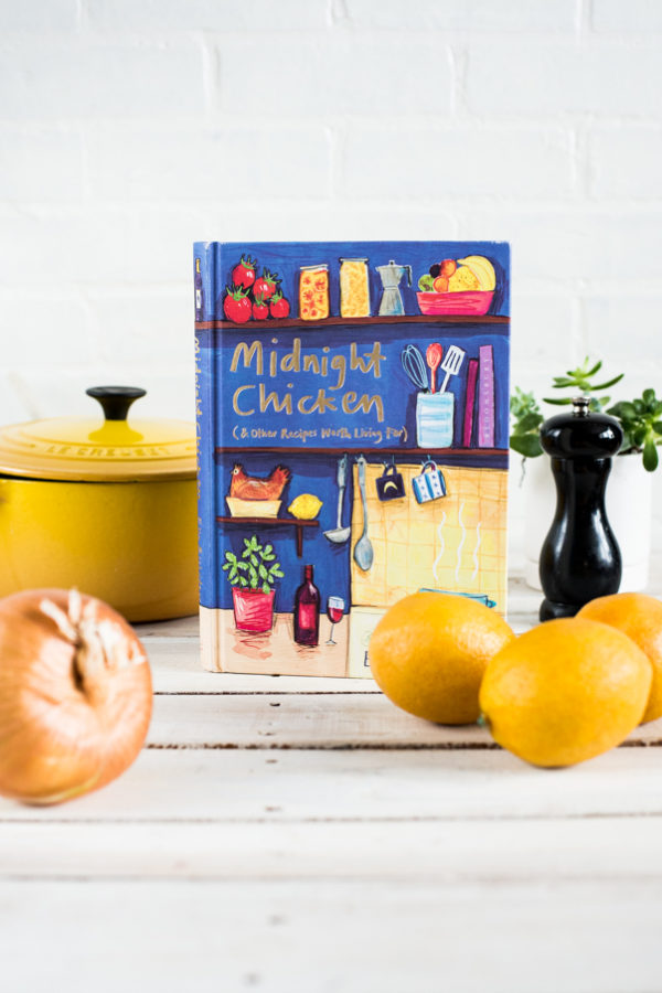 Yellow lemons and Midnight Chicken Cookbook on a white background