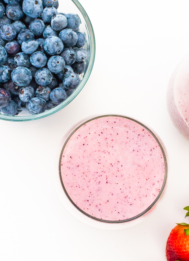 birds eye view of strawberry blueberry smoothie with blueberries on a white background