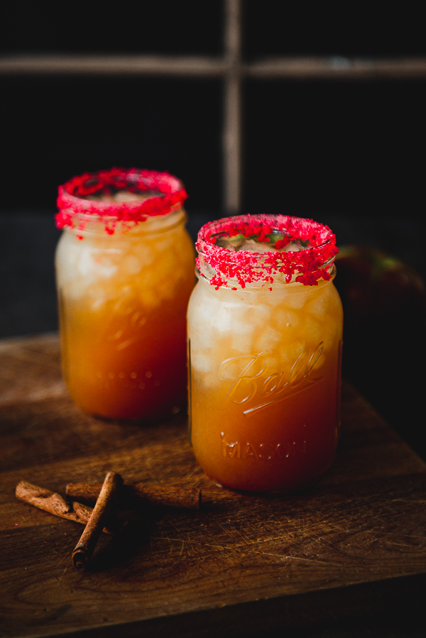 Image is of 2 mason jars on a wood background filler with a fireball cider cocktail