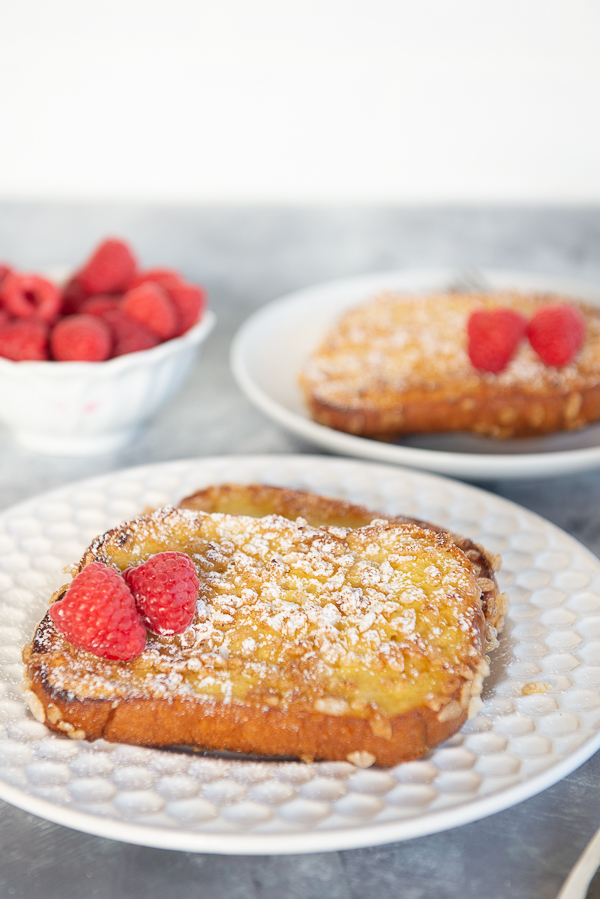 Image is of 2 plates of double dip French Toast recipe on a grey background with raspberries