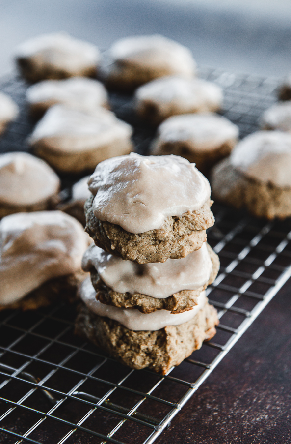 Image is a stack of 3 double chocolate drop cookies with chocolate frosting on a cooling rack